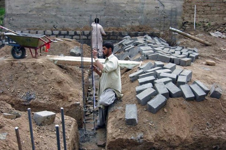 Man sets up the iron columns of a house.