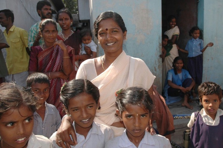 Indian woman has two Indian children in her arms.