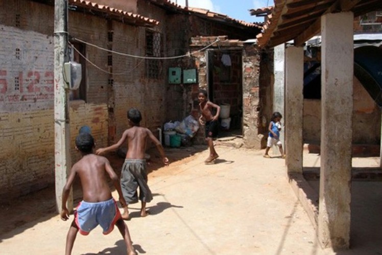 Three boys are playing in the alley of a slum.