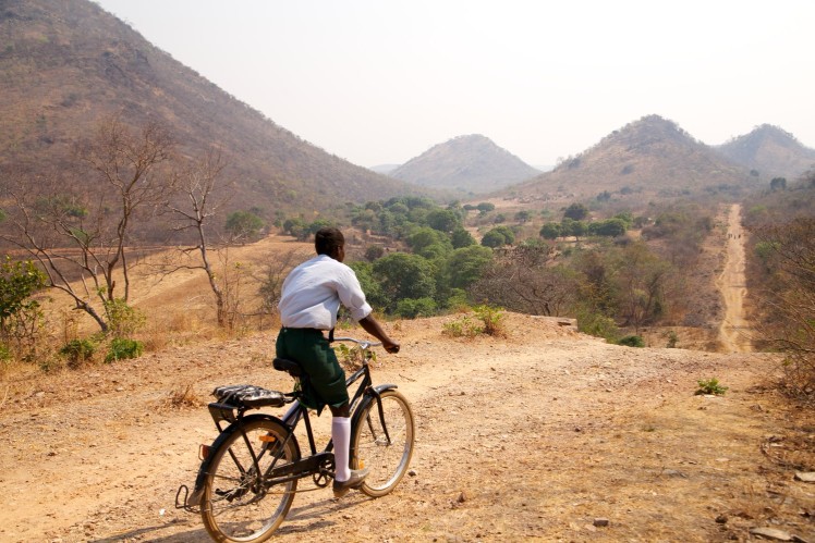 Schoolboy goes home by bicycle.