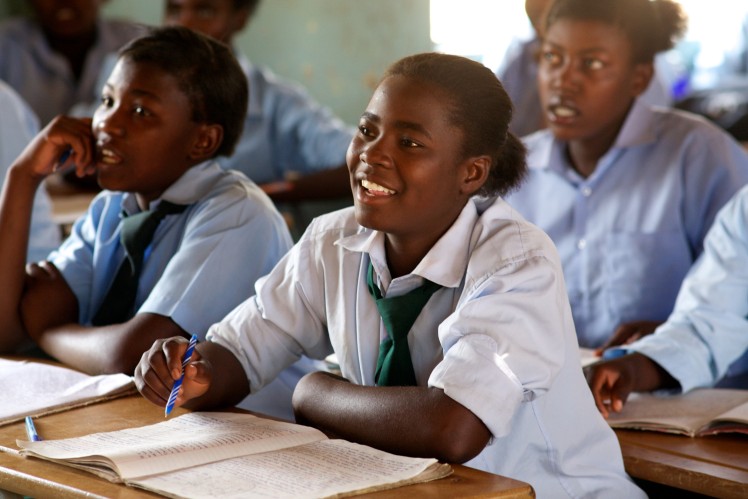 Happy schoolgirl writing in her notebook. 
