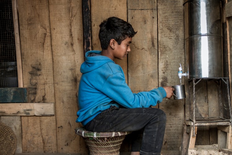 Child filling drinking water from a metal container