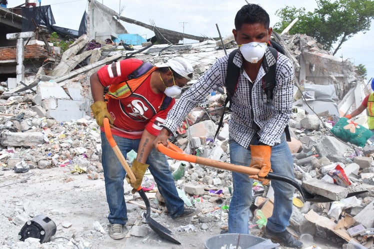 Two men clear the damage of the earthquake.