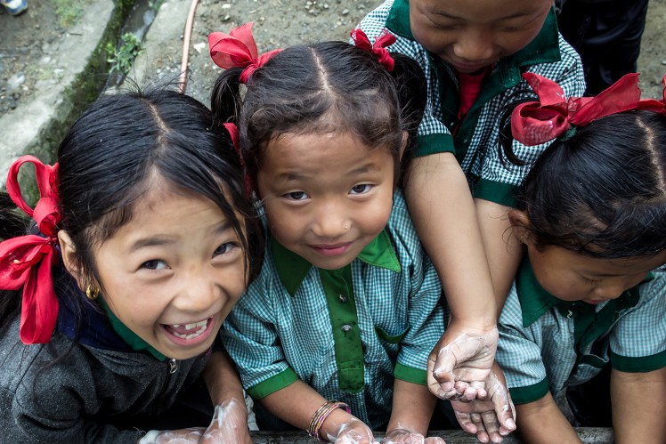Children wash their hands.