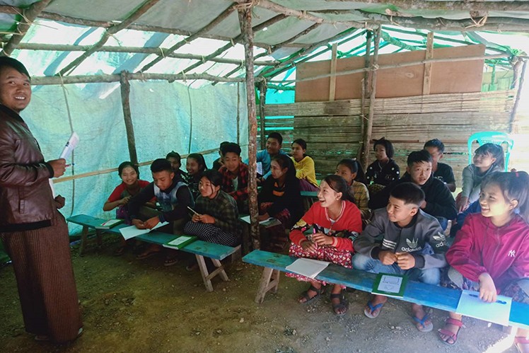 School class in Myanmar in a makeshift classroom built from wood and tarpaulin